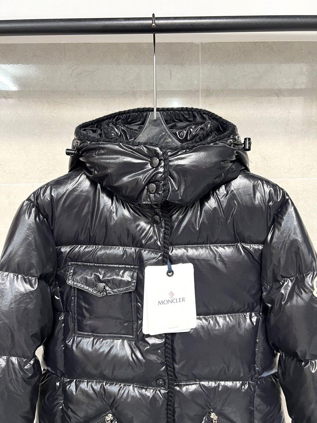 Moncler long puffer jacket, glossy black hooded puffer with front zipper and hanging tags