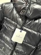 Moncler long puffer jacket chest detail, glossy black with emblem patch and hanging tag