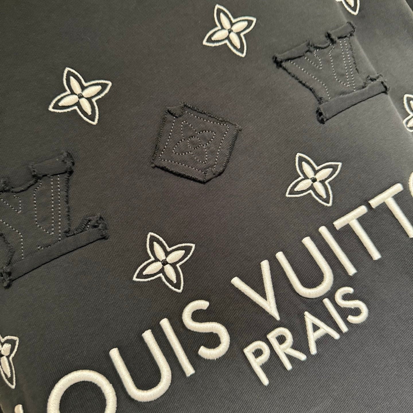Louis Vuitton short-sleeve T-shirt detail, white floral print and “PRAIS” text
