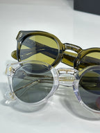 Overlapping chrome glasses with round frames; gold and clear styles with green lenses