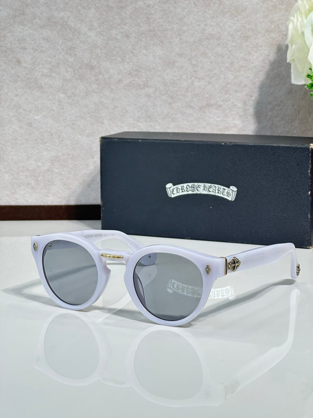 Chrome glasses with white round frames and gray-tinted lenses