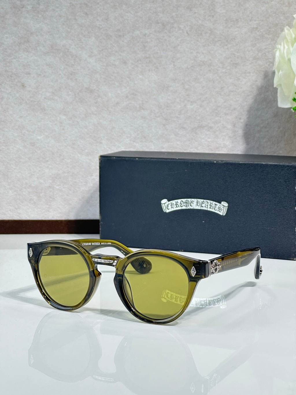 Chrome glasses with gold round frames and green-tinted lenses
