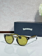 Chrome glasses with gold round frames and green-tinted lenses