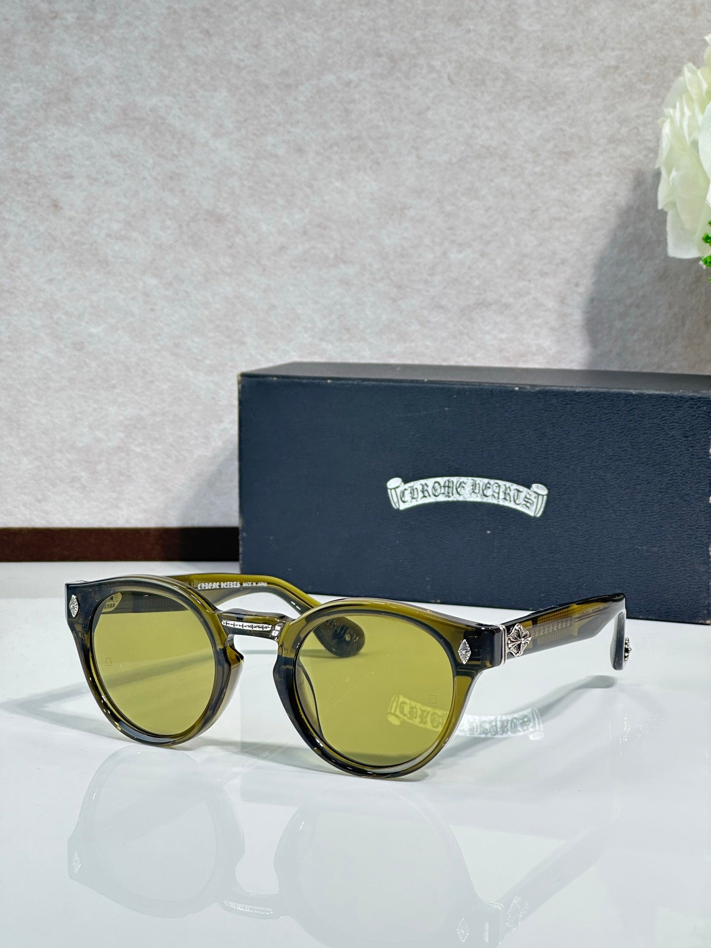 Chrome glasses with gold round frames and green-tinted lenses