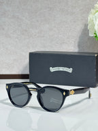 Chrome glasses with black round frames and dark lenses, gold accents