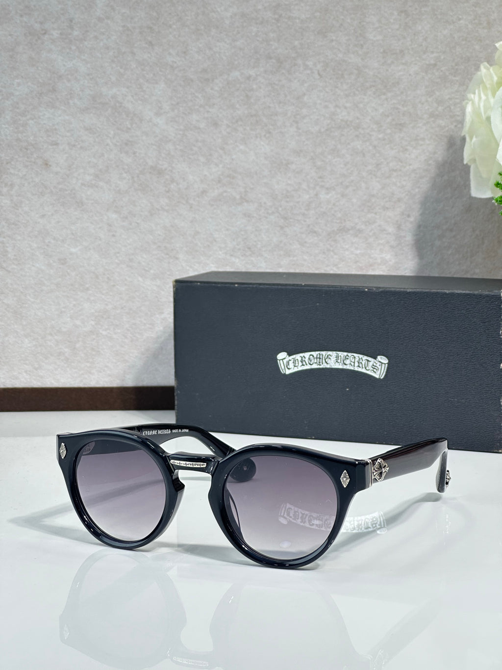 Chrome glasses with black round frames and purple-gray tinted lenses