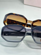 Oversized square sunglasses with tortoise front and navy-tinted lenses.