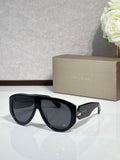 Black cat-eye sunglasses with dark smoke lenses and gold logo detail