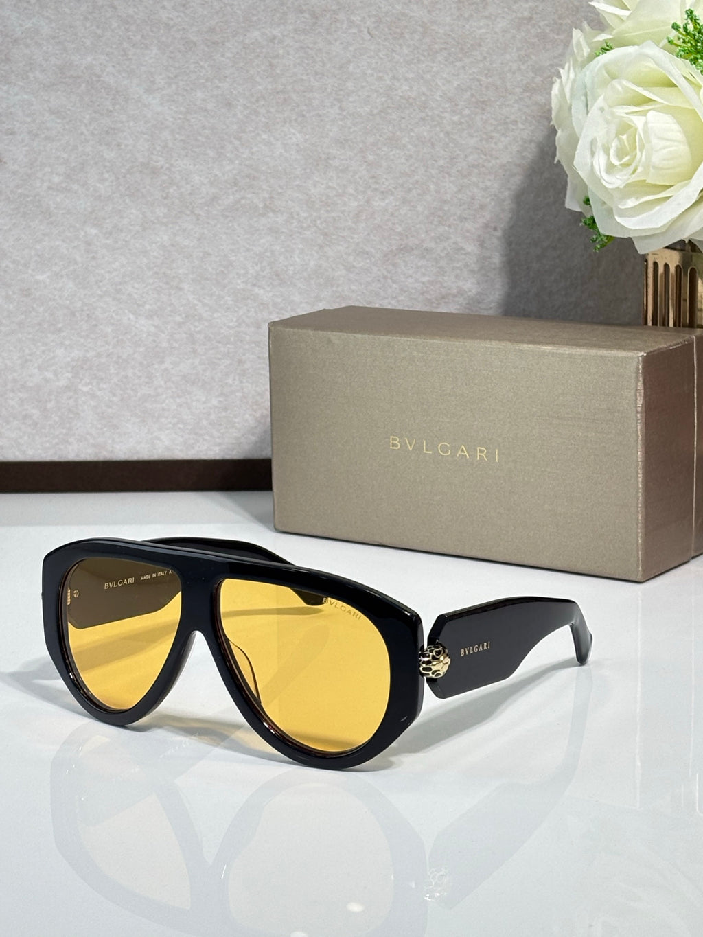 Black cat-eye sunglasses with yellow mirrored lenses and gold logo detail