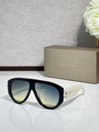 Black cat-eye sunglasses with reflective green-tinted lenses and gold logo detail
