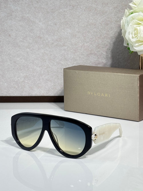 Black cat-eye sunglasses with reflective green-tinted lenses and gold logo detail