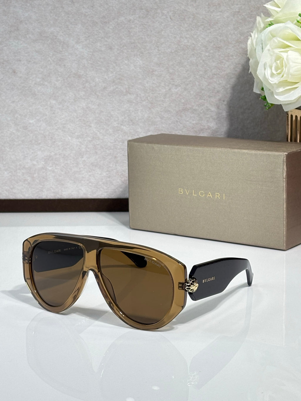 Brown cat-eye sunglasses with dark lenses and gold logo detail
