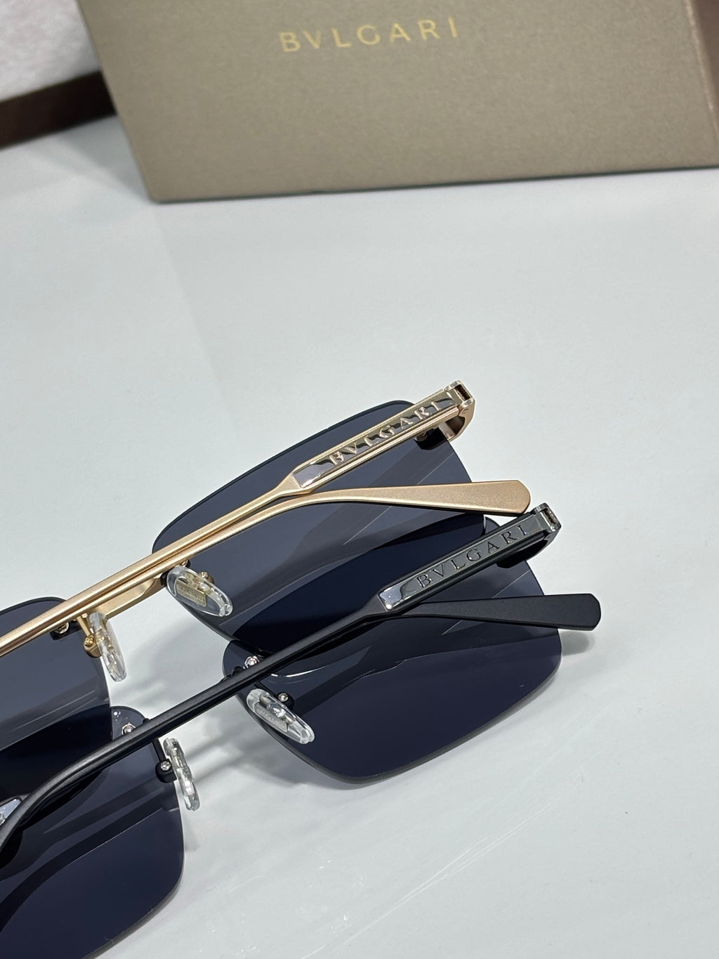 Close-up of metal eyeglasses with dark blue lenses and engraved gold bridge