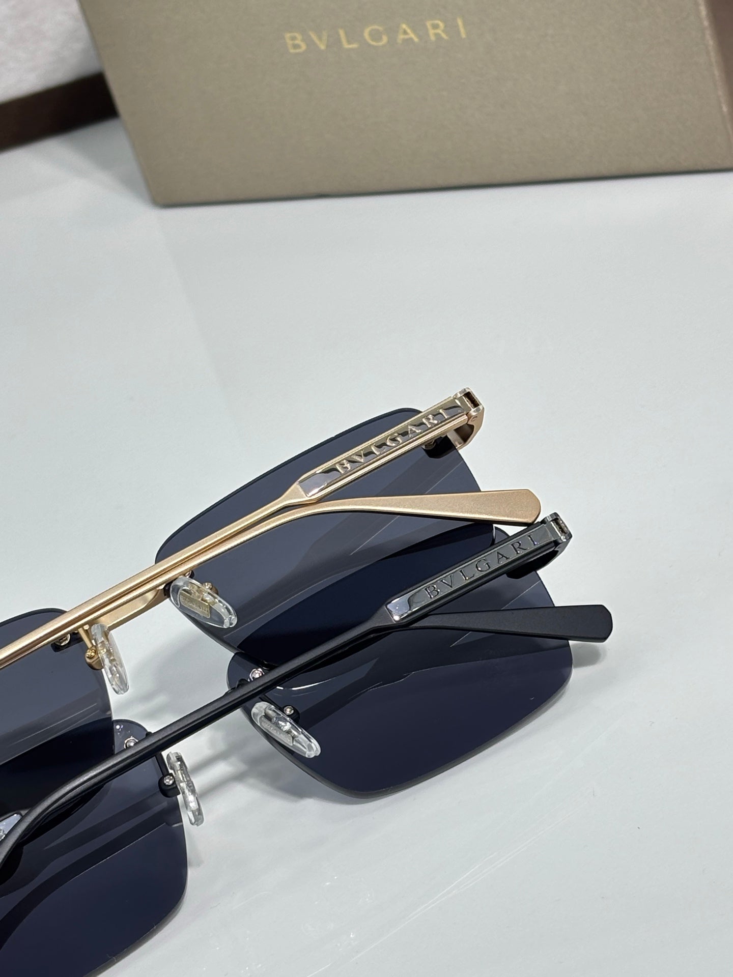Close-up of metal eyeglasses with dark blue lenses and engraved gold bridge