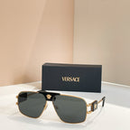 Versace sunglasses with dark green lenses, gold frame, and black bridge logo detail