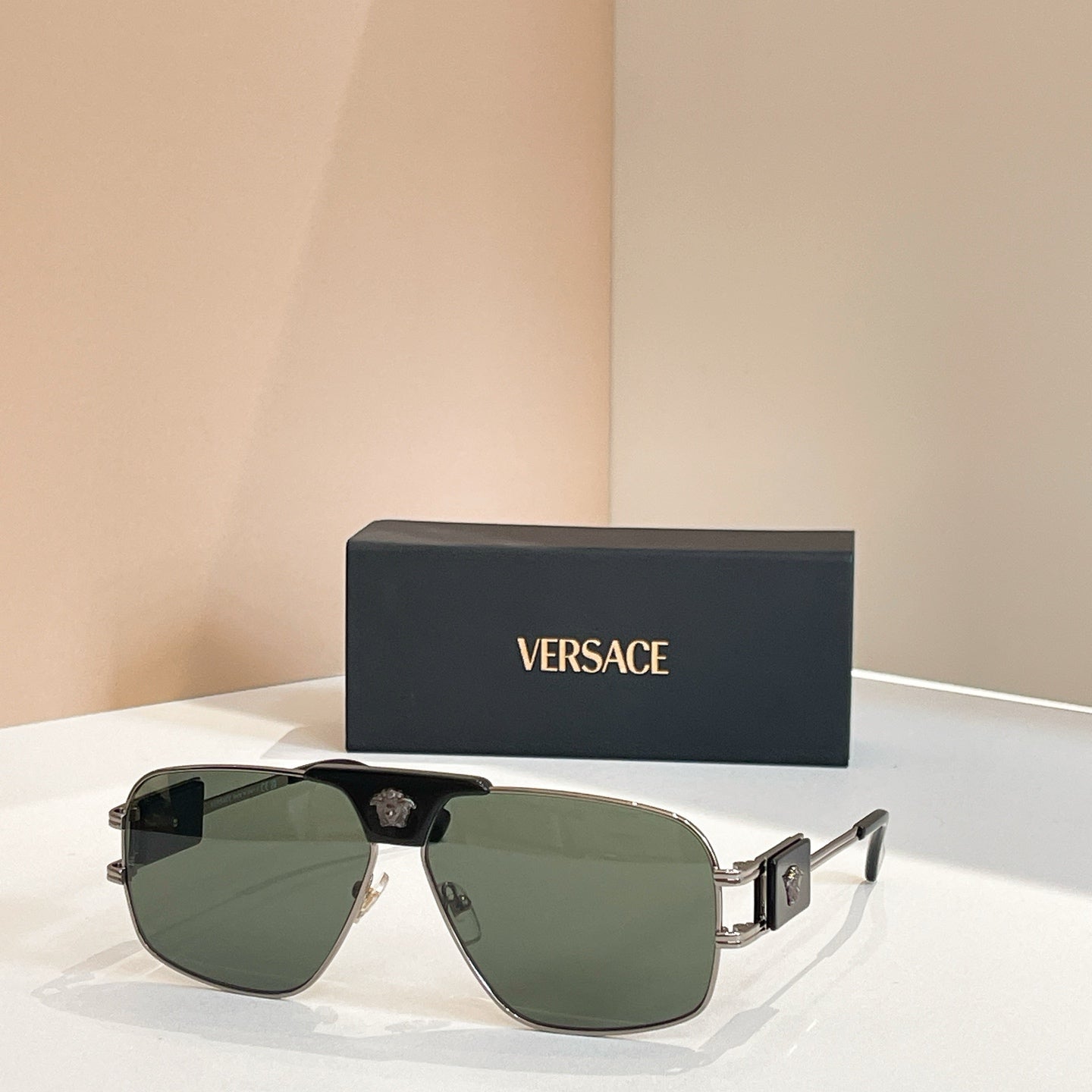 Versace sunglasses with dark green lenses, black frame, and gold logo detail