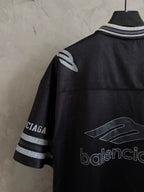 Balenciaga black polo shirt back quarter view with striped cuffs and graphic