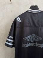 Balenciaga black polo shirt with large graphic on chest and striped sleeve band