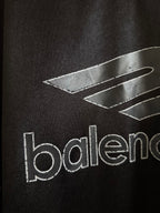 Black Balenciaga polo shirt with graphic lines and partial 'balenciaga' text