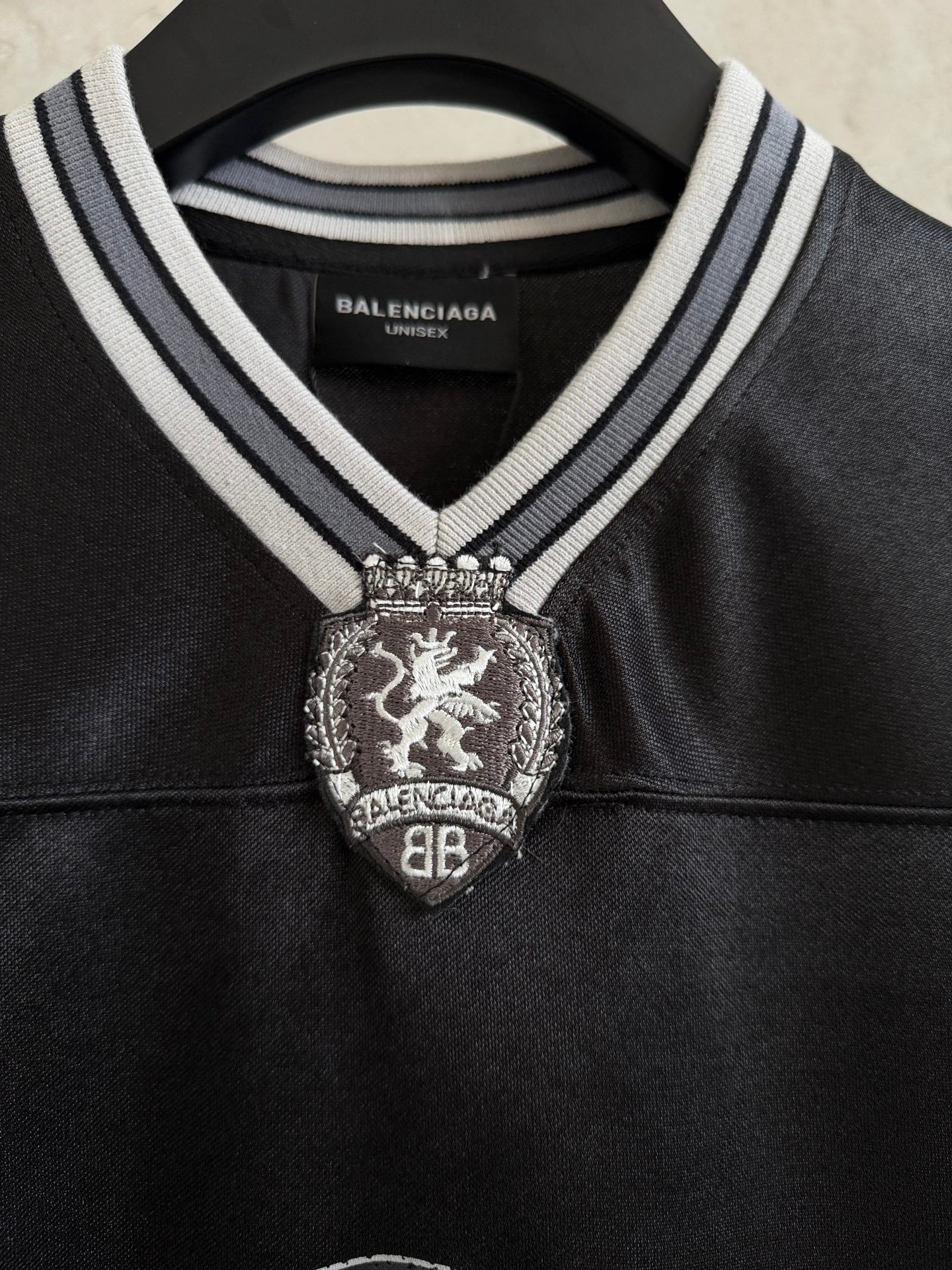 Black polo shirt with striped collar and Balenciaga crest patch at the chest