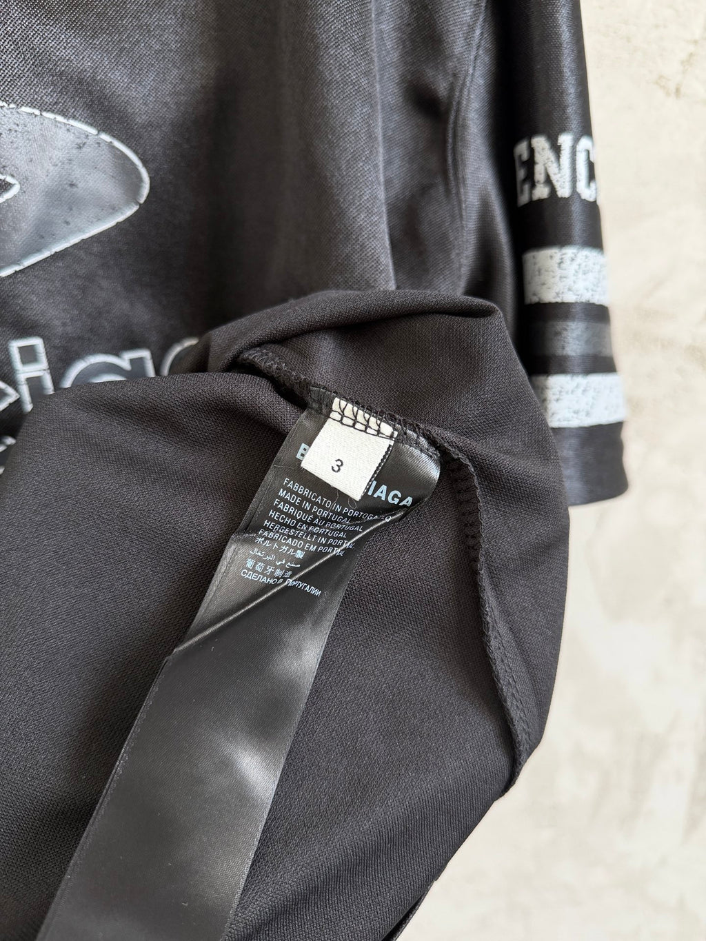 Black Balenciaga polo shirt with neck label tag and draped sleeve