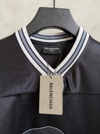 Black Balenciaga polo shirt with striped collar and hanging price tag