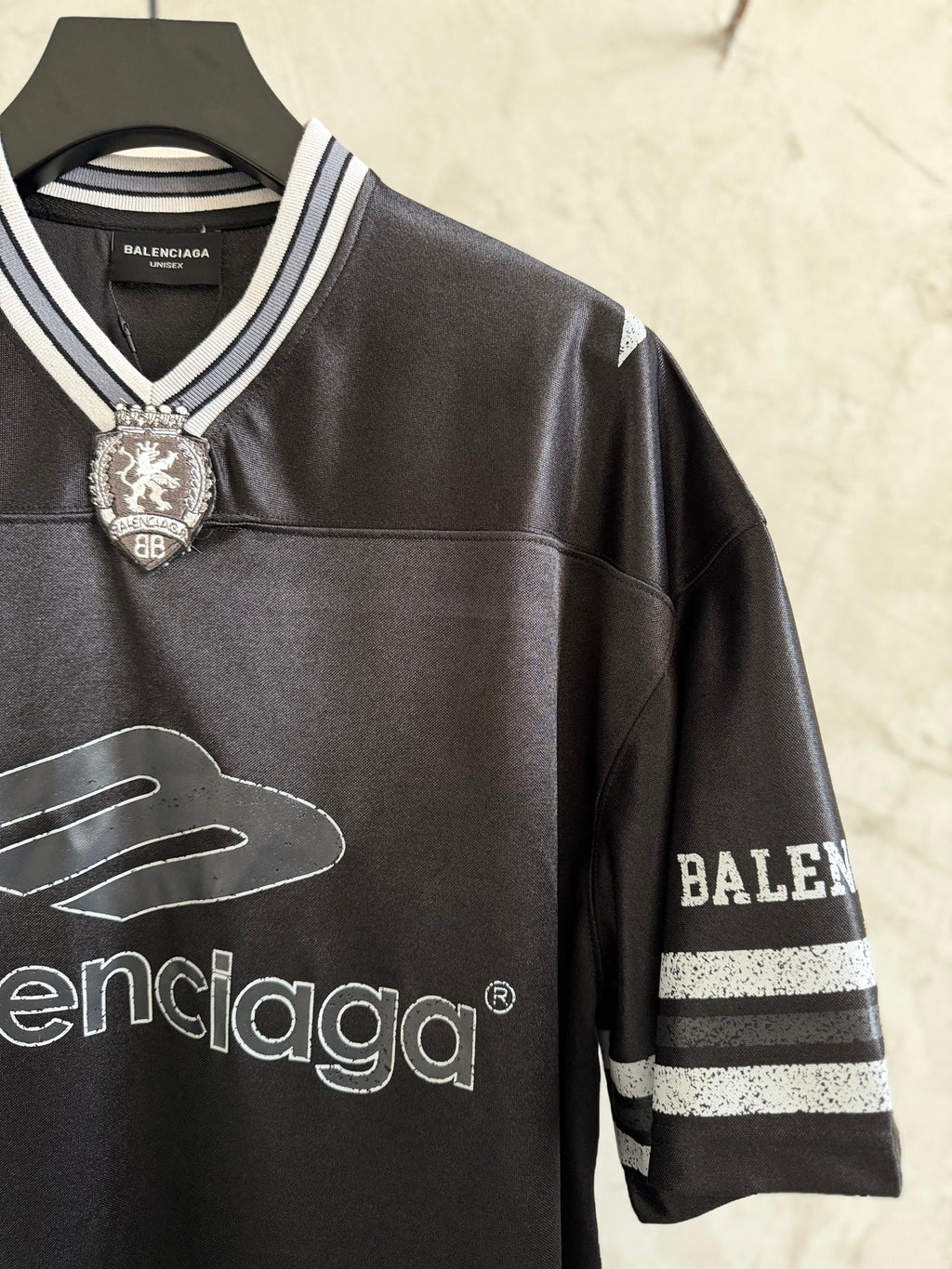 Black Balenciaga polo shirt with embroidered crest, striped sleeve trim, and logos