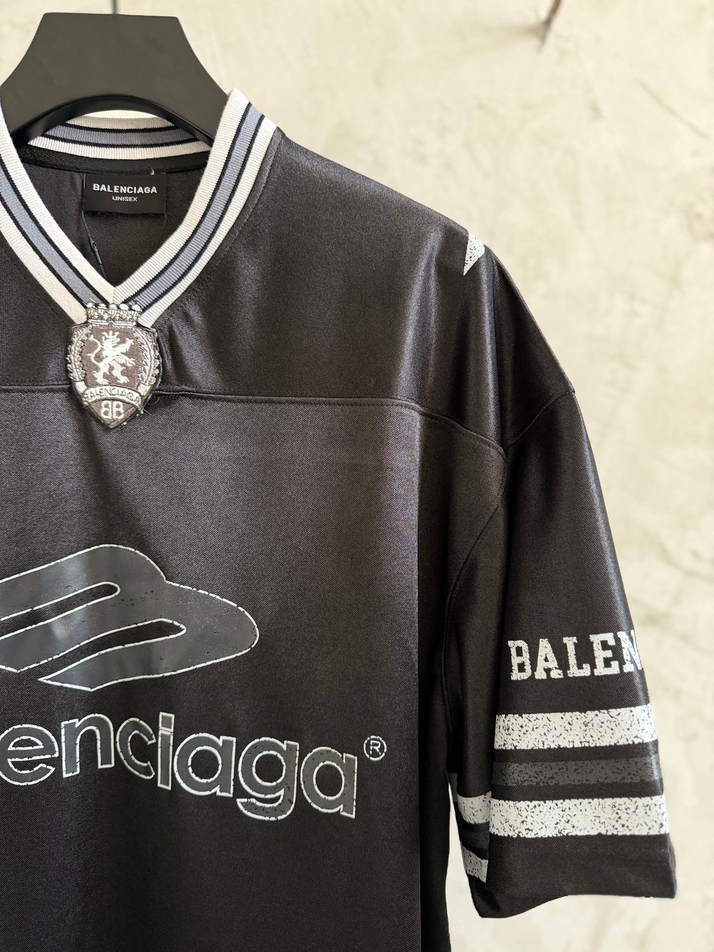 Black Balenciaga polo shirt with embroidered crest, striped sleeve trim, and logos