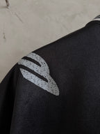 Balenciaga black polo sleeve close-up with white abstract logo graphic