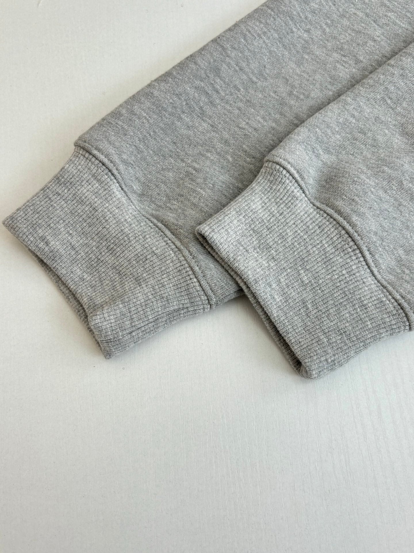 Light gray sweatshirt cuffs and hem, long sleeves with stitched edges