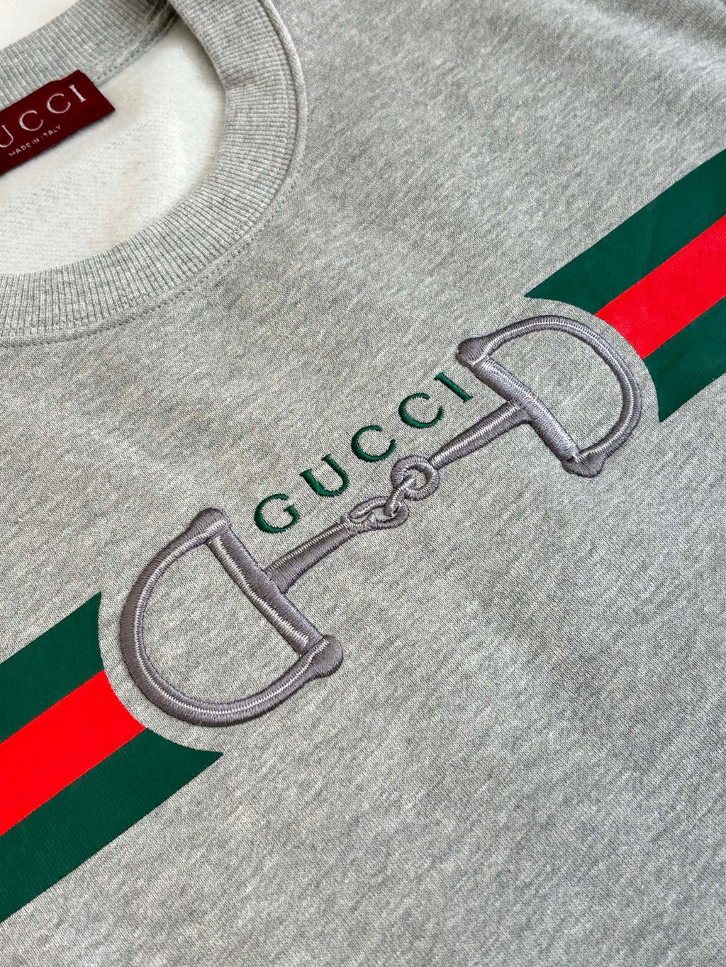 Light gray sweatshirt graphic close-up with green and red stripe and Gucci detail