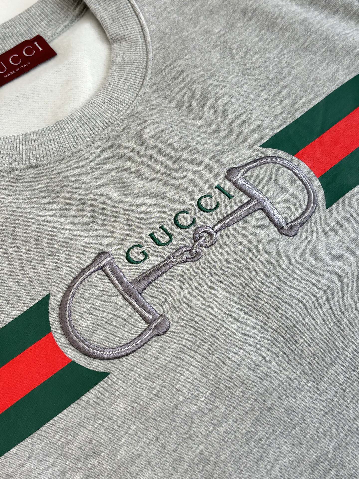 Light gray sweatshirt graphic close-up with green and red stripe and Gucci detail