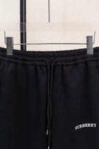 Black elastic waistband and drawstring close-up with side logo embroidery