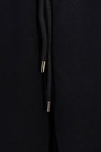 Black drawstring with metal aglets at the end of the cord