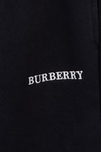 Black pants with embroidered BURBERRY logo text on the fabric