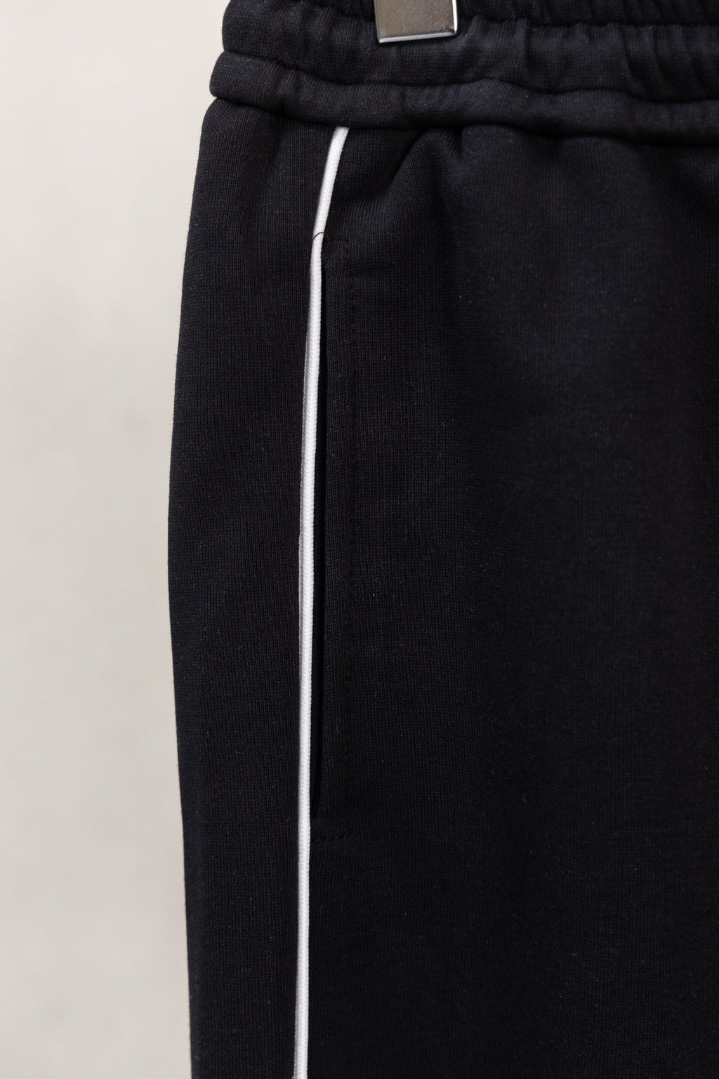 Black pants with elastic waistband and white drawstring ties