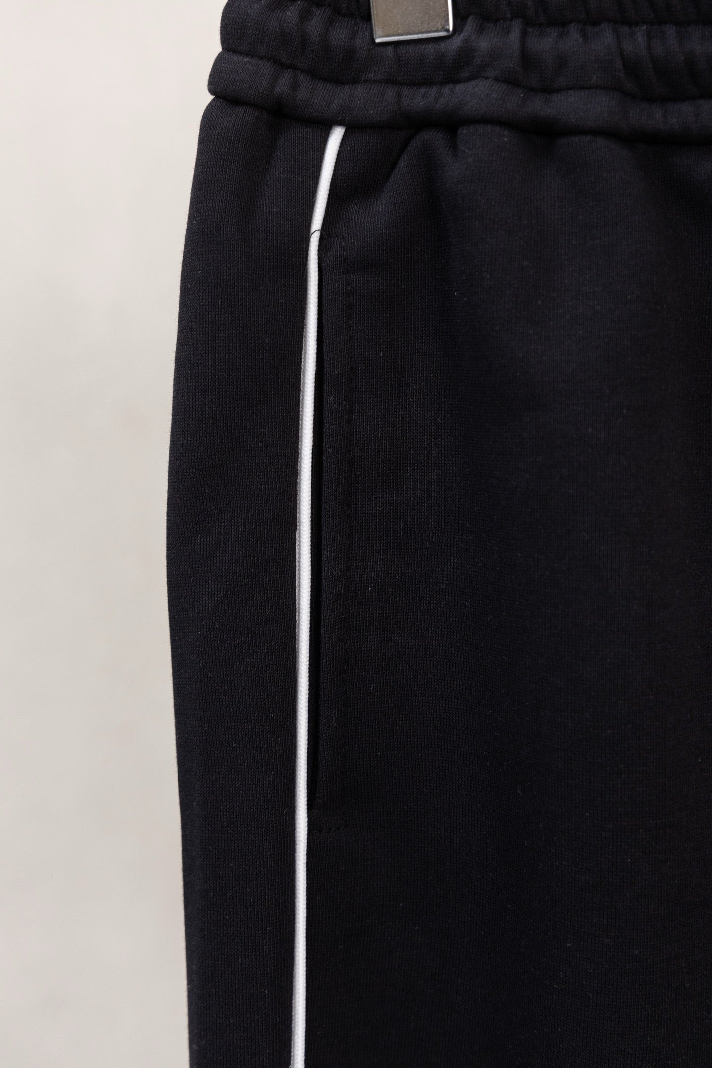 Black pants with elastic waistband and white drawstring ties