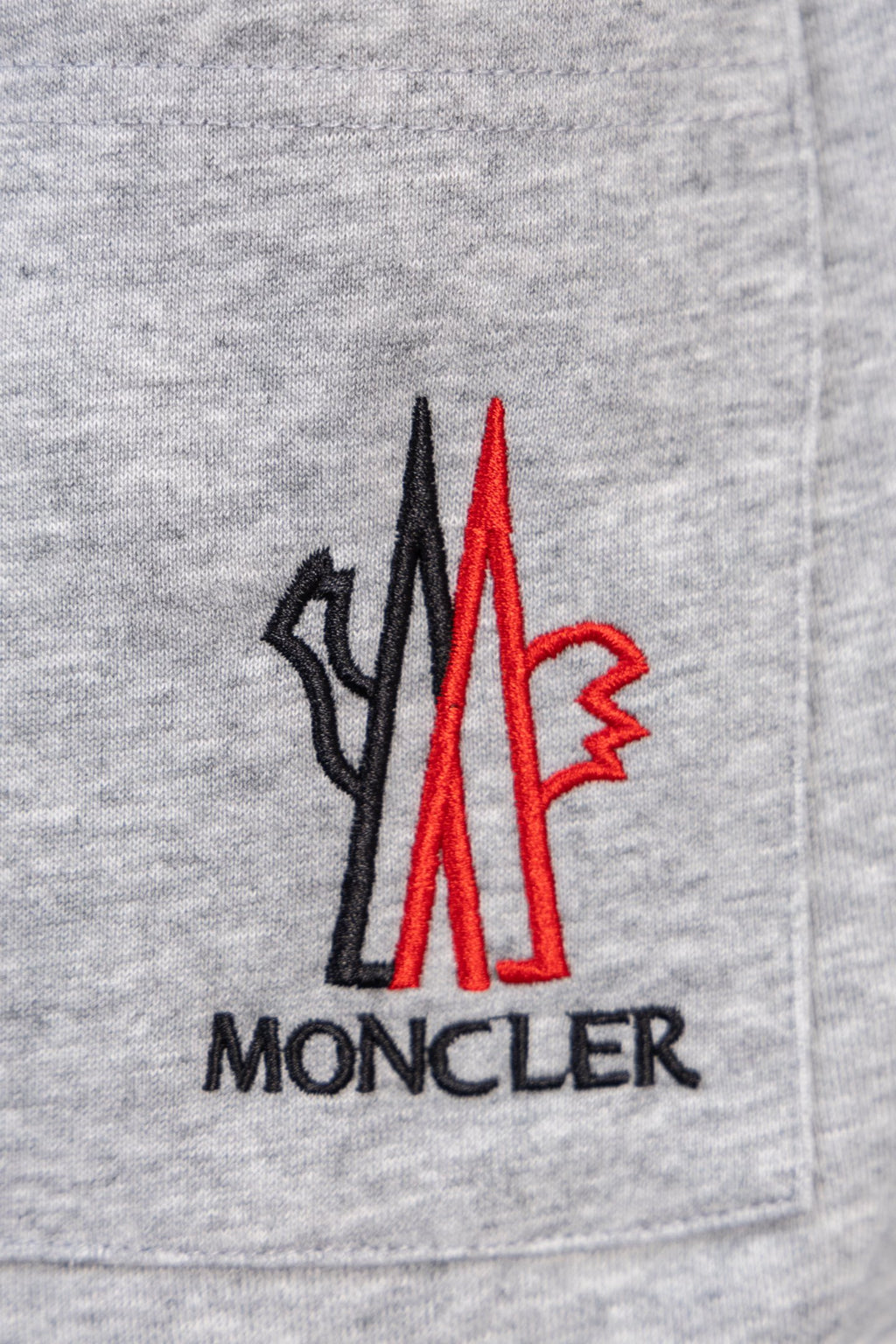 Moncler gray sweatpants with front pocket and large red Moncler logo