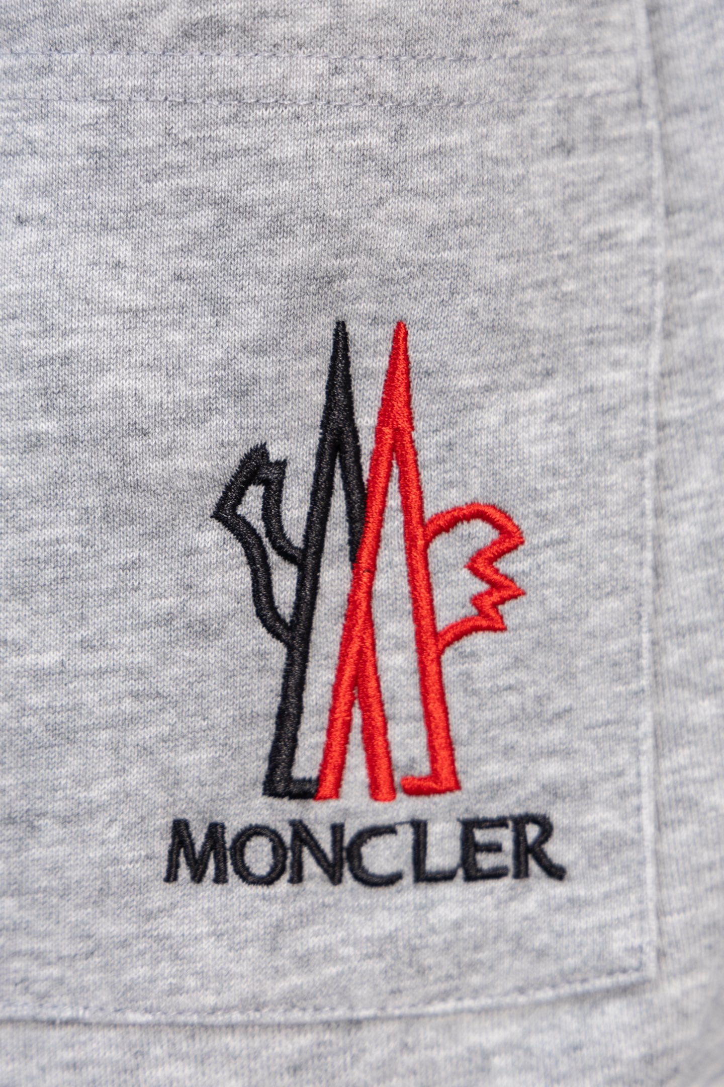 Moncler gray sweatpants with front pocket and large red Moncler logo