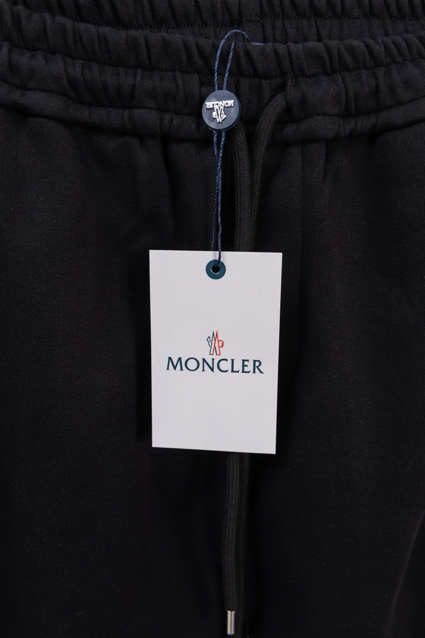 Moncler pants with elastic waistband, drawstring, and MONCLER hang tag