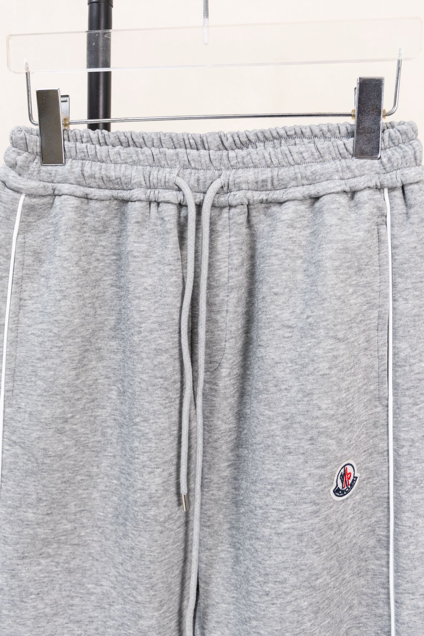 Moncler gray sweatpants with elastic waistband, drawstring, and side emblem