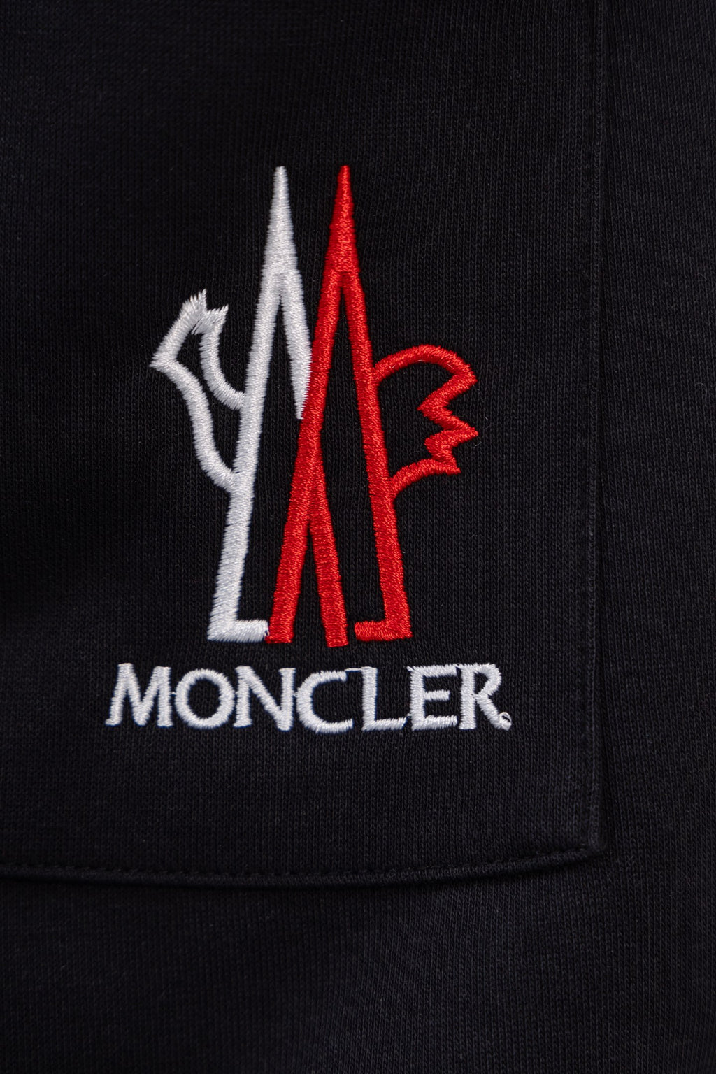 Moncler crest logo on black pants pocket, red and white
