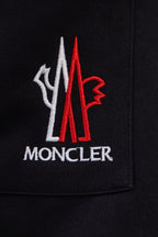 Moncler crest logo on black pants pocket, red and white