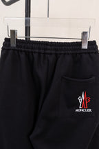 Black pants with elastic waistband, side pocket, and Moncler logo patch
