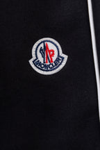Moncler crest logo patch on black pants fabric