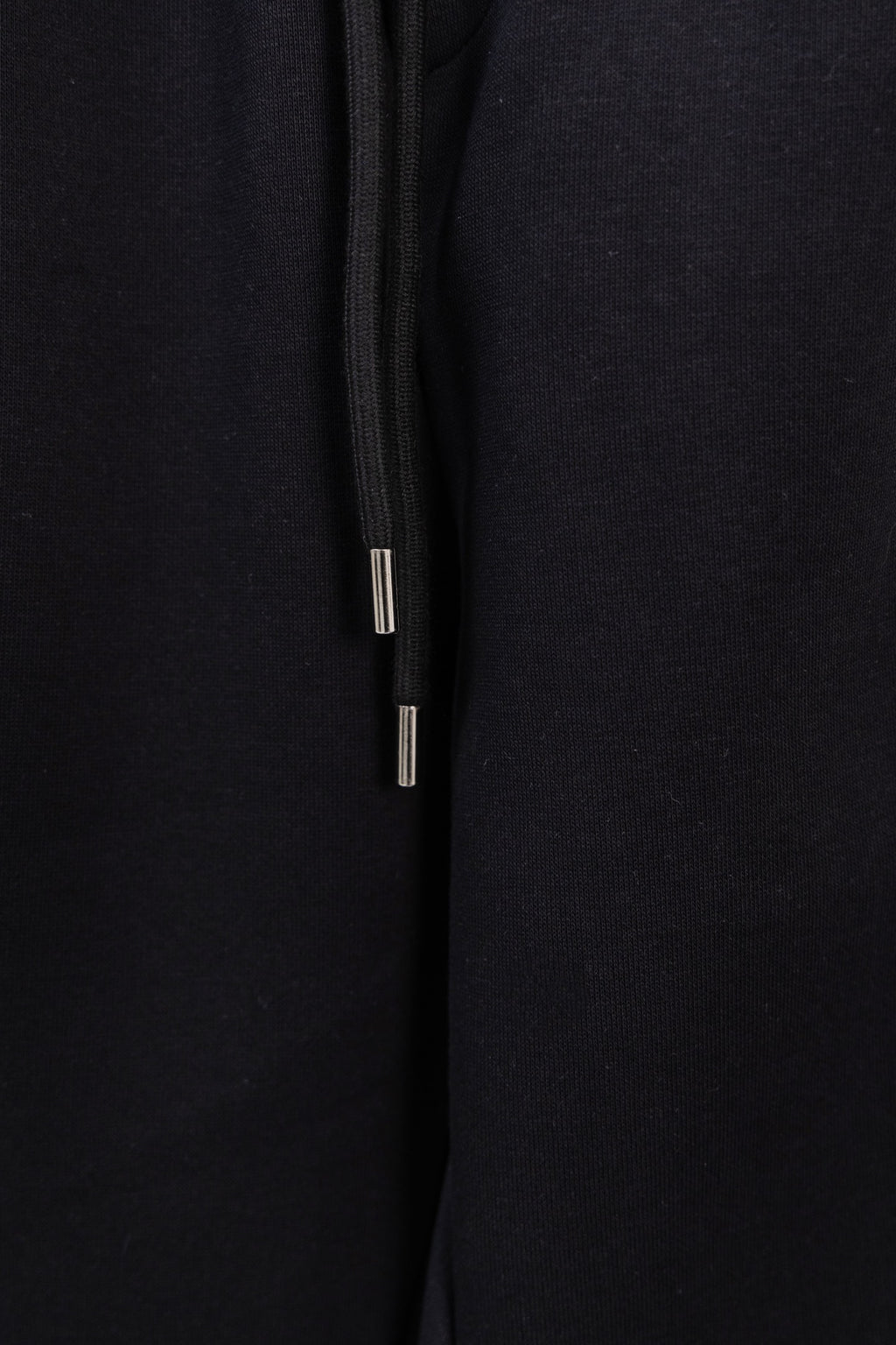 Black drawstring pants with metal-tipped cords and smooth fabric