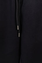 Black drawstring pants with metal-tipped cords and smooth fabric