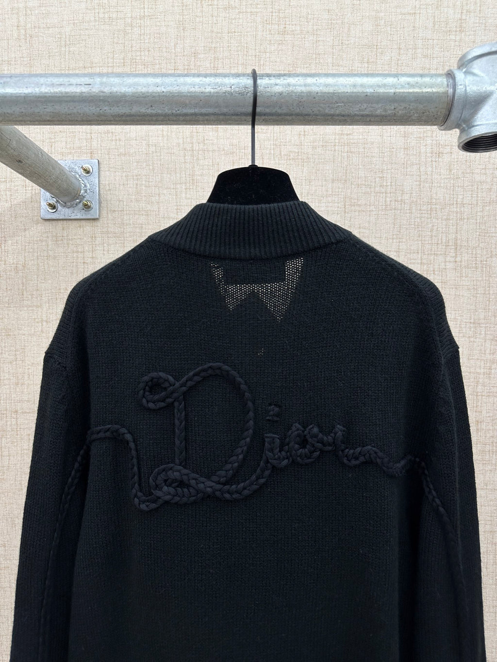 Dark knit jacket back with raised logo embroidery and ribbed high collar