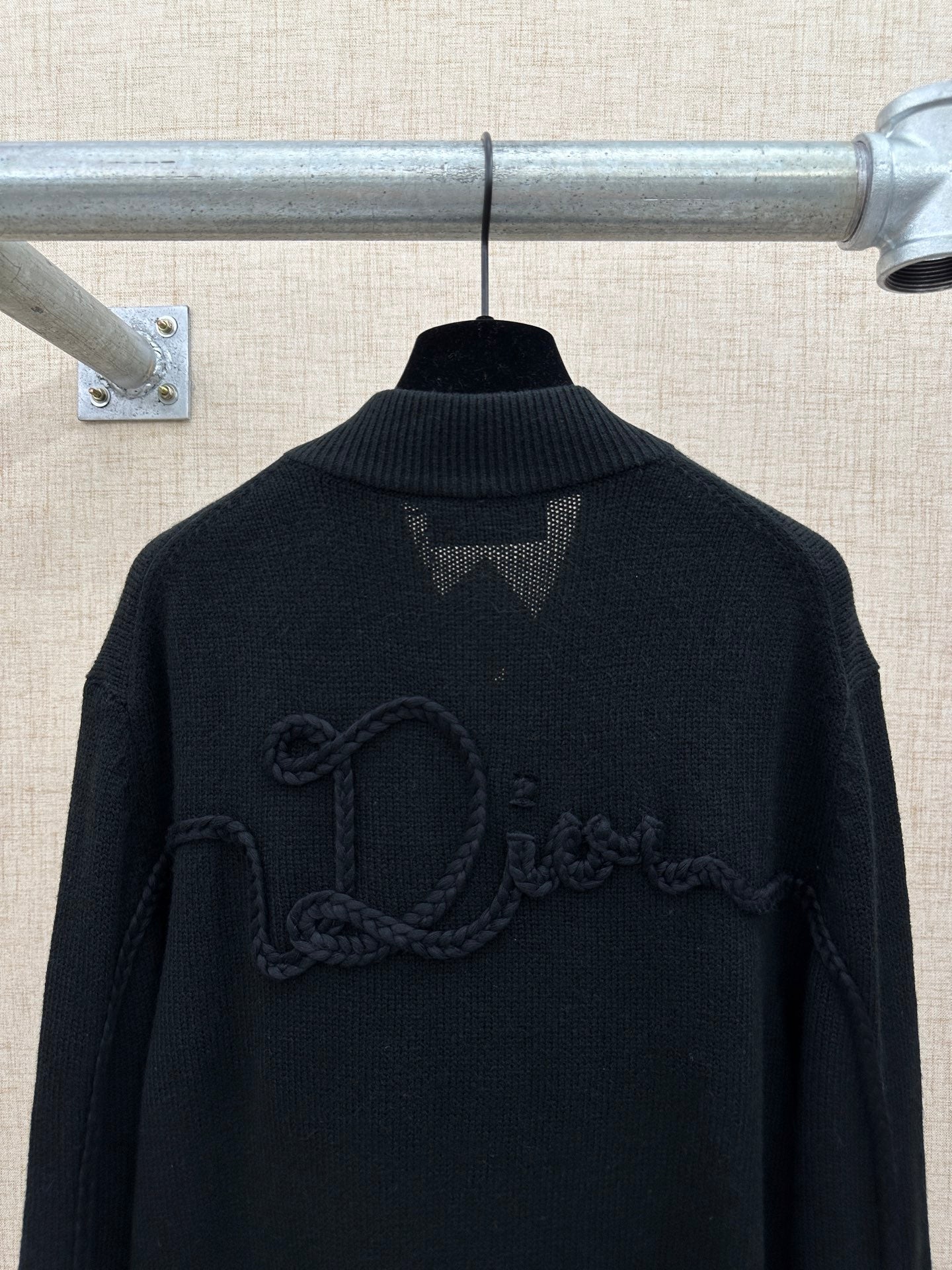 Dark knit jacket back with raised logo embroidery and ribbed high collar