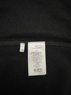 Dark knit jacket interior showing size and fabric care label, size M